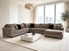A modern L-shaped sectional sofa upholstered in taupe corduroy fabric, styled in a bright, contemporary living room with a white marble coffee table and a large white textured area rug.