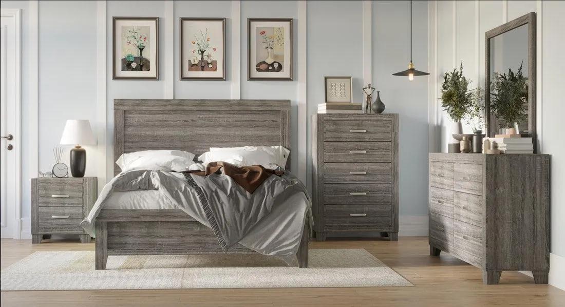 A rustic gray wood bedroom furniture set including a bed frame, nightstand, dresser, and chest of drawers, styled in a modern bedroom with light gray walls, framed art, and a mirror.