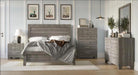 A rustic gray wood bedroom furniture set including a bed frame, nightstand, dresser, and chest of drawers, styled in a modern bedroom with light gray walls, framed art, and a mirror.